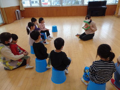 保育者の話を聞く子ども