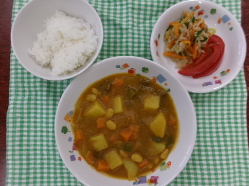 今日の給食の白ご飯・ビーフカレー・切り干し大根のサラダ・トマトがお皿に盛りつけられている。