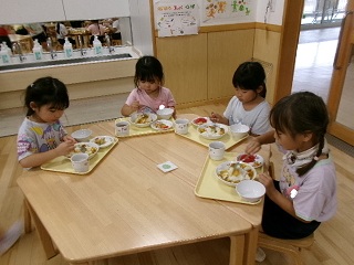 こども達がの給食のトマトを食べている様子