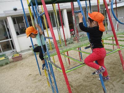 登降棒ジムで遊ぶ子ども二人