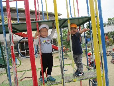 登降棒ジム中段からこちらを見ている子ども二人