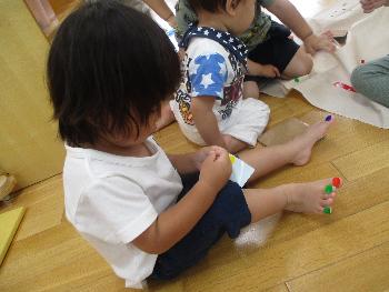 足の爪にシールを貼る子