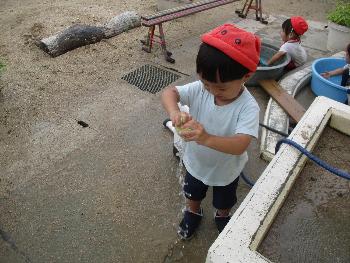 スポンジを絞ると水が出てくることに気づいた子ども