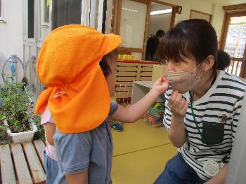 保育者にゼラニウムを届ける子ども