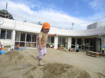 築山から築山へ渡る子ども