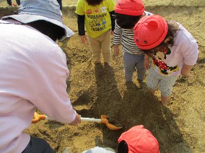 裸足で砂場の土の感触を楽しむ子どもたち