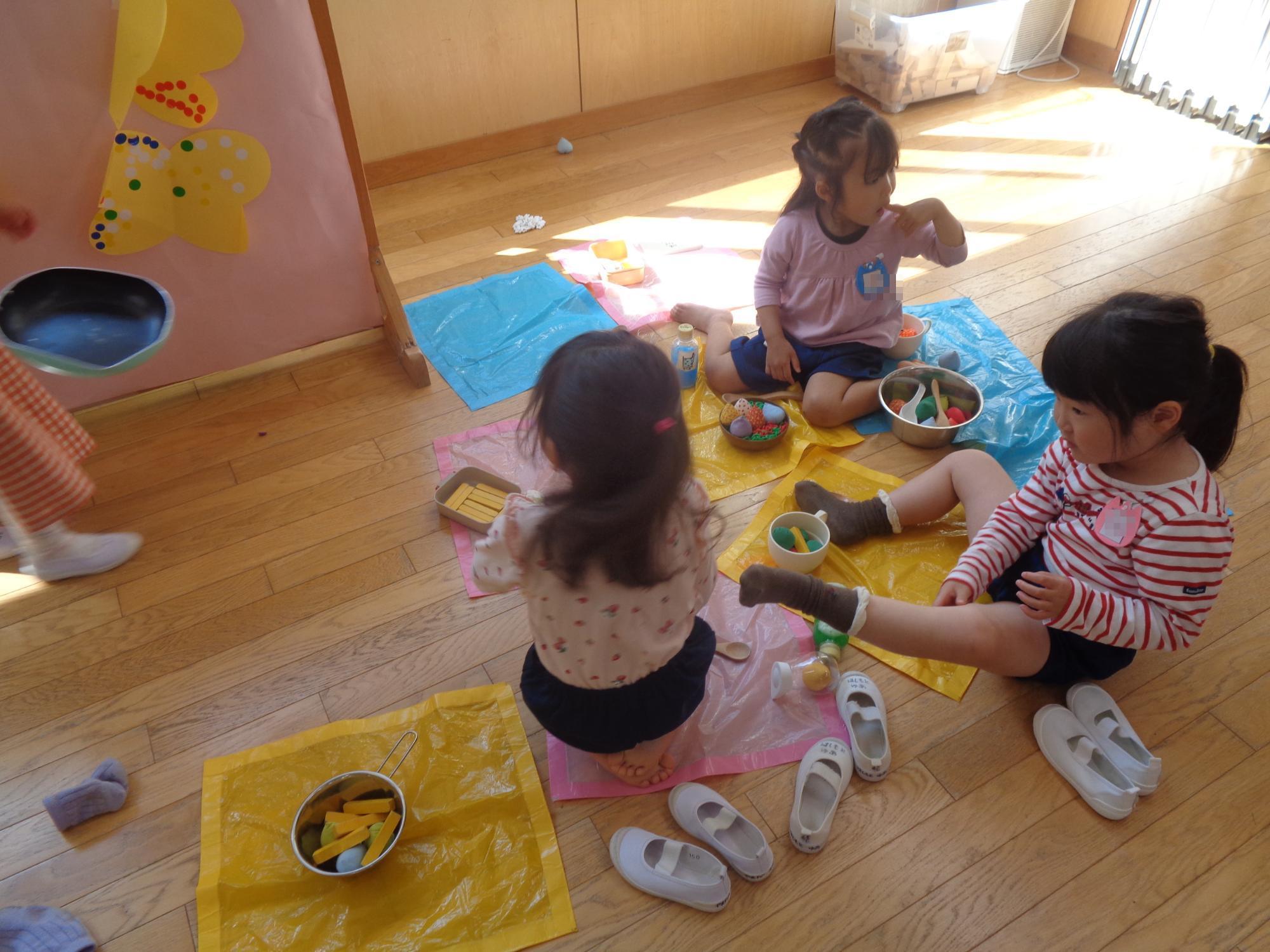 保育室でピクニックごっこをする子ども