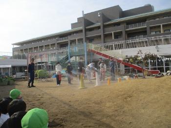 消火訓練をする保育者