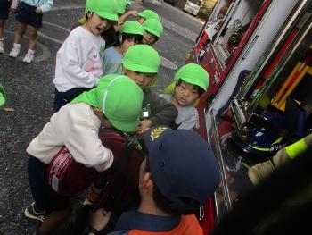 消火用のホースを見せてもらう子ども