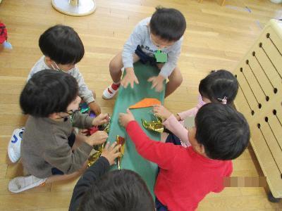保育者に足をくすぐられる子ども