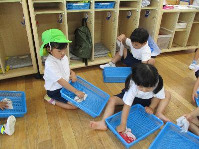 自分のかごを拭く3歳児