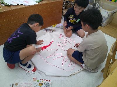 幼年消防クラブ組替式で使用する火の絵を描いている。