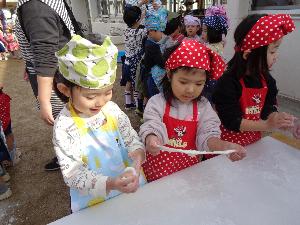 餅を伸ばす子ども