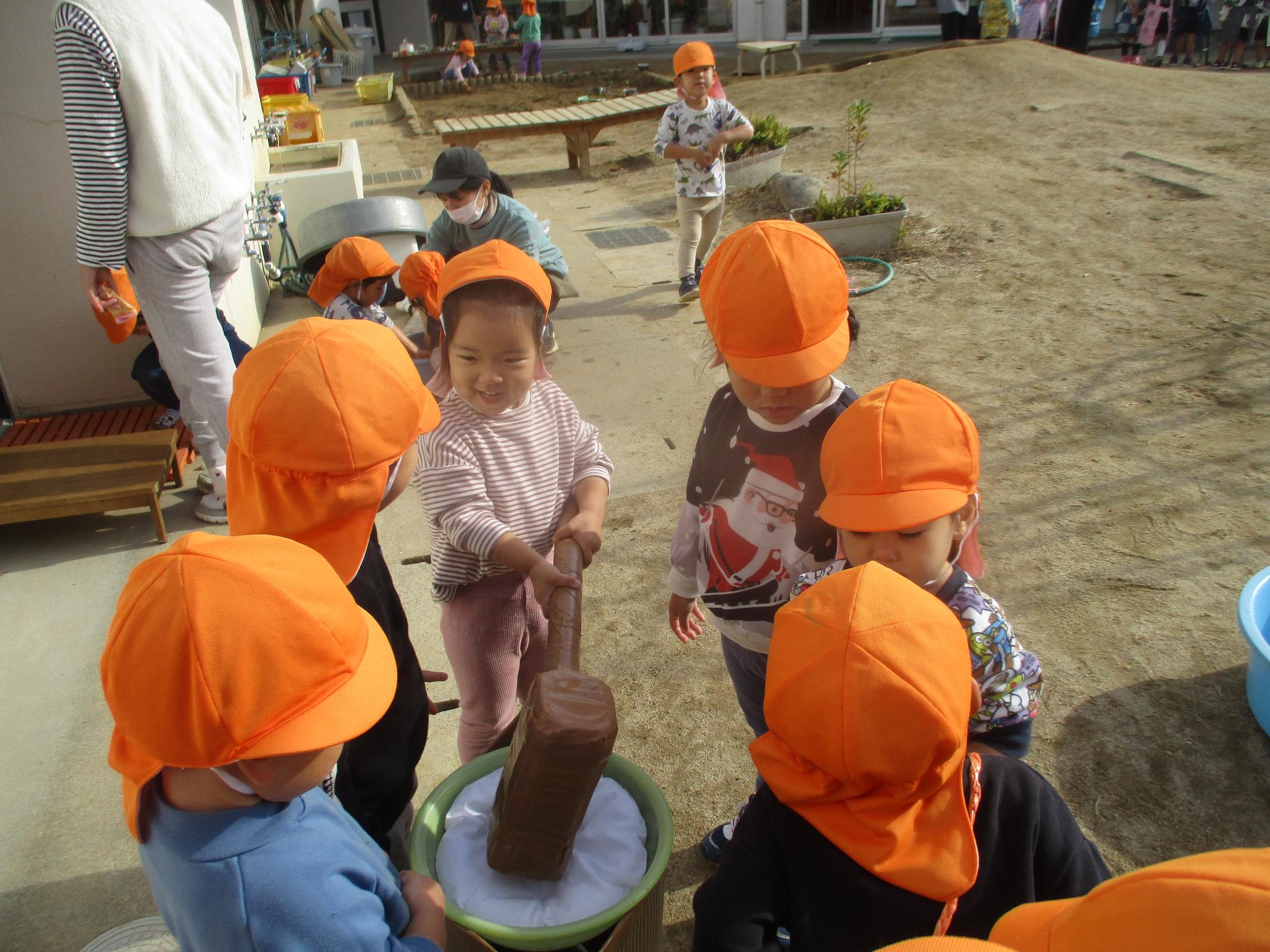 餅をつく真似をする子ども