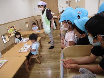 乳児の食べている様子を見るみんな