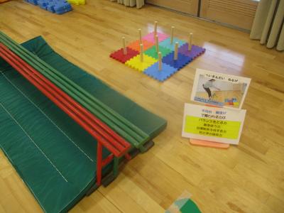 平均台に乗って輪投げをする