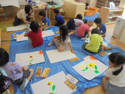 ひまわりの絵を描く子ども達