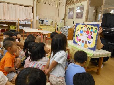 とんぼ組のお友達が、ひかり保育園の開園についての紙芝居を見ている画像