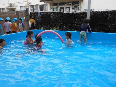 友達2人がスポンジ素材の棒を使ってアーチを作り、その下をワニ歩きでくぐっています
