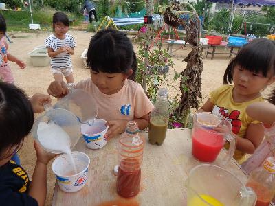 色水を混ぜてかき氷のシロップ作りをする子ども
