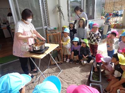 りんごを煮る保育者
