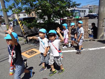 手を挙げて歩く子ども