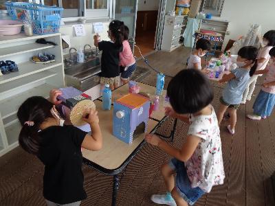 自作のかき氷機を使ってかき氷作り遊びをする子ども達