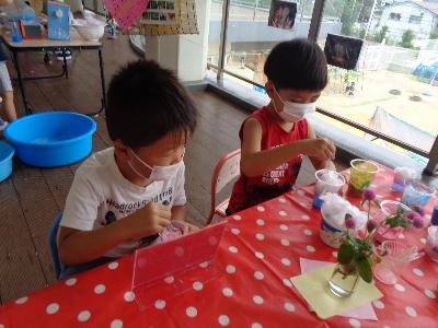 色水と綿で作ったかき氷を食べる真似をする子ども達