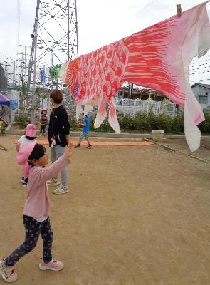 こいのぼりに手を伸ばす子ども