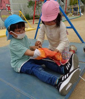 こいのぼりに紐を通している子ども