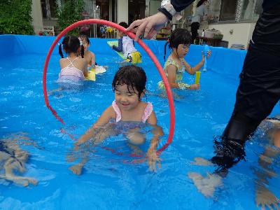 プールの中でフープをくぐる子ども