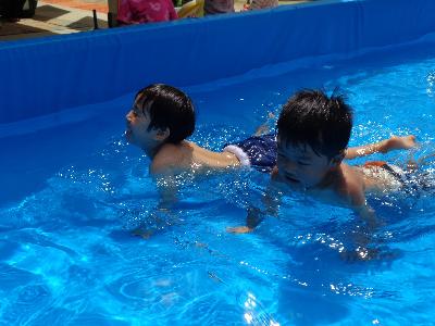 プールの中でワニ歩きをする子ども