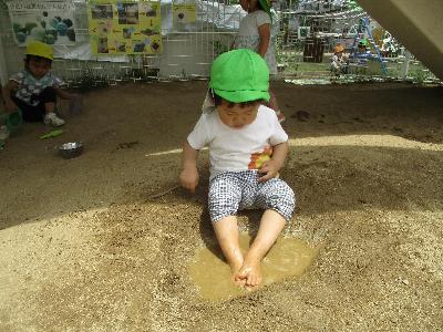 泥水の中に足を付けている子ども