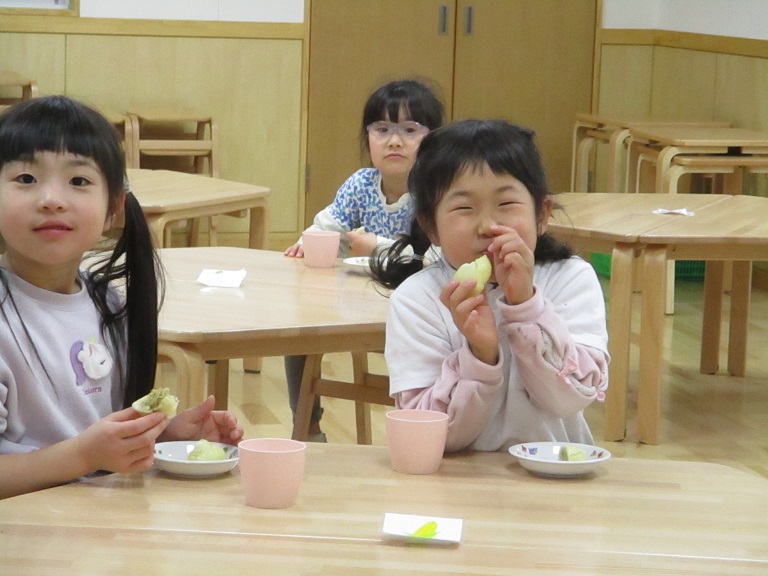 子どもたちが、楽しそうにテーブルを囲んで肉まんを食べている。