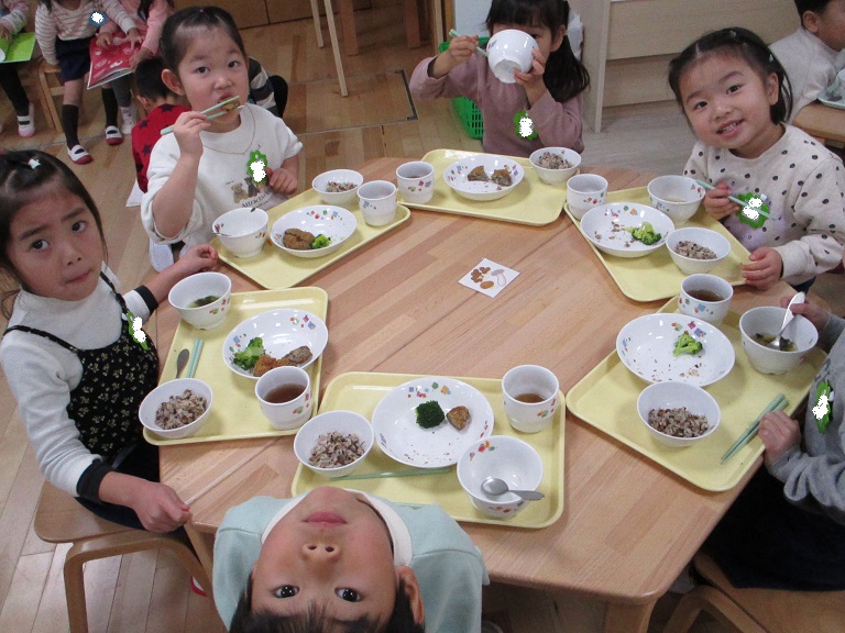 机を囲んで子どもたちが給食を楽しそうに食べている様子