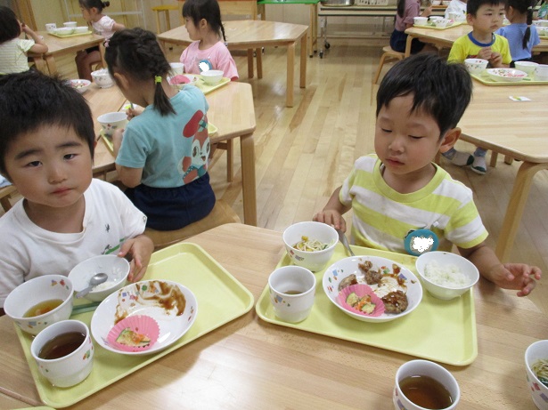 こども達２人がテーブルを囲んで食べている様子。