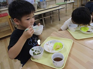 こどもたちがテーブルを囲んで食べている様子。