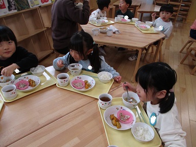 こどもたちがテーブルを囲んで食べている様子。