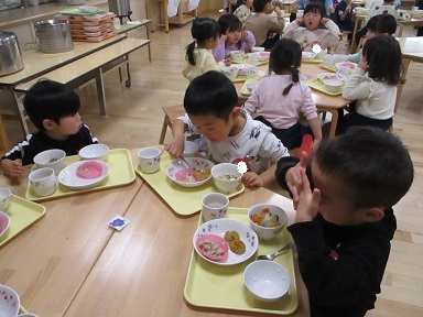 こどもたちがテーブルを囲んで食べている様子。