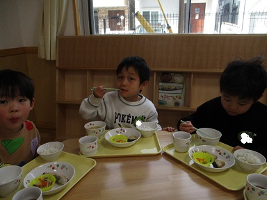 こどもたちがテーブルを囲んで食べている様子。