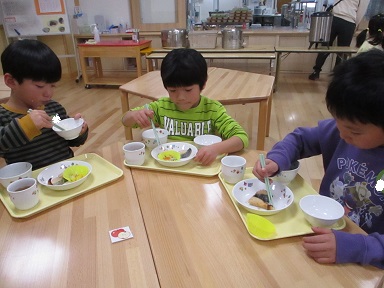 こどもたちがテーブルを囲んで食べている様子。