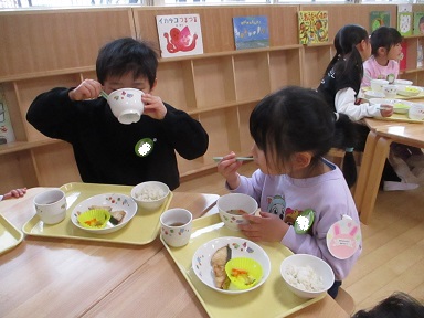 こどもたちがテーブルを囲んで食べている様子。