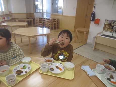 こどもたちがテーブルを囲んで食べている様子。