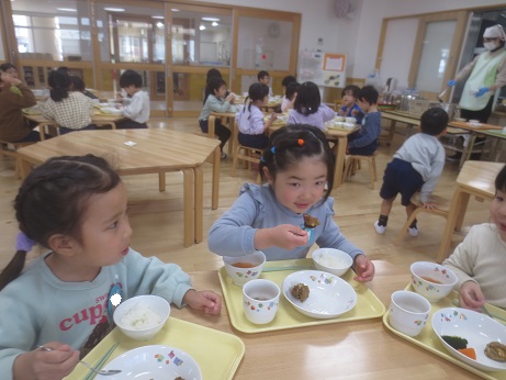 こどもたちがテーブルを囲んで楽しそうに食べている様子。