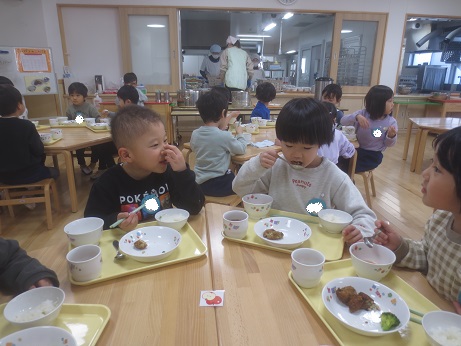 こどもたちがテーブルを囲んで楽しそうに食べている様子。