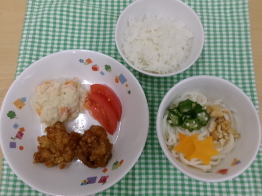 給食の白ご飯・チキン南蛮・アリオリサラダ・トマト・七夕そうめんがお皿に盛りつけられている。