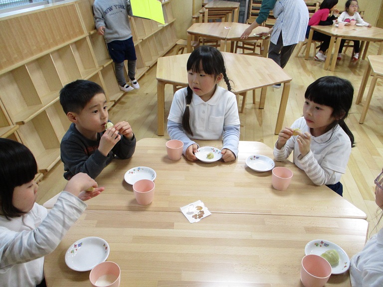 子どもたちが、楽しそうに肉まんを食べている。