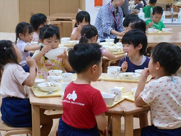 こどもたちがテーブルを囲んで食べている様子。