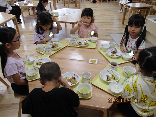 こどもたちがテーブルを囲んで食べている様子。