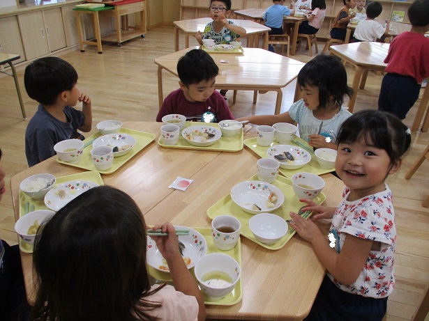 こどもたちがテーブルを囲んで楽しそうに食べている様子。